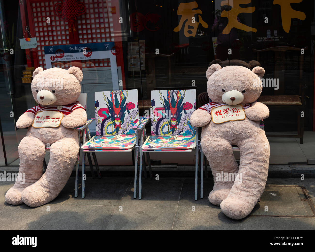 Deux belles grandes équilibrées à l'ours assis sur des chaises colorées Spice World Hot Spot Restaurant Sichuan dans Clarke Quay Singapour Asie Banque D'Images