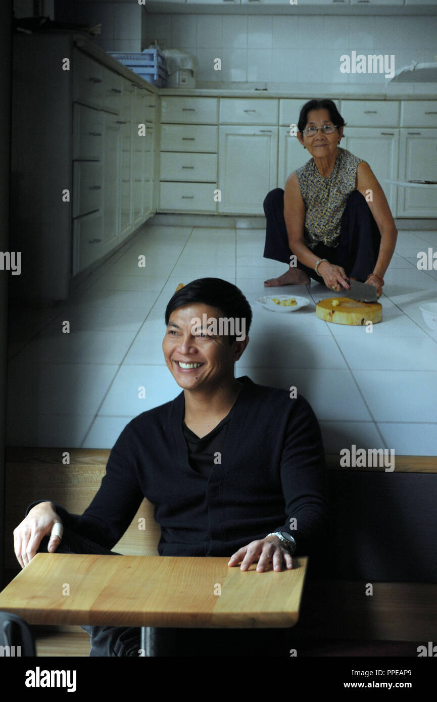 Le Tan-Loc photographe vietnamien Nguyen dans son restaurant 'Koriander trop' dans le quartier Haidhausen de Munich. Dans l'arrière-plan, une de ses photographies. Banque D'Images
