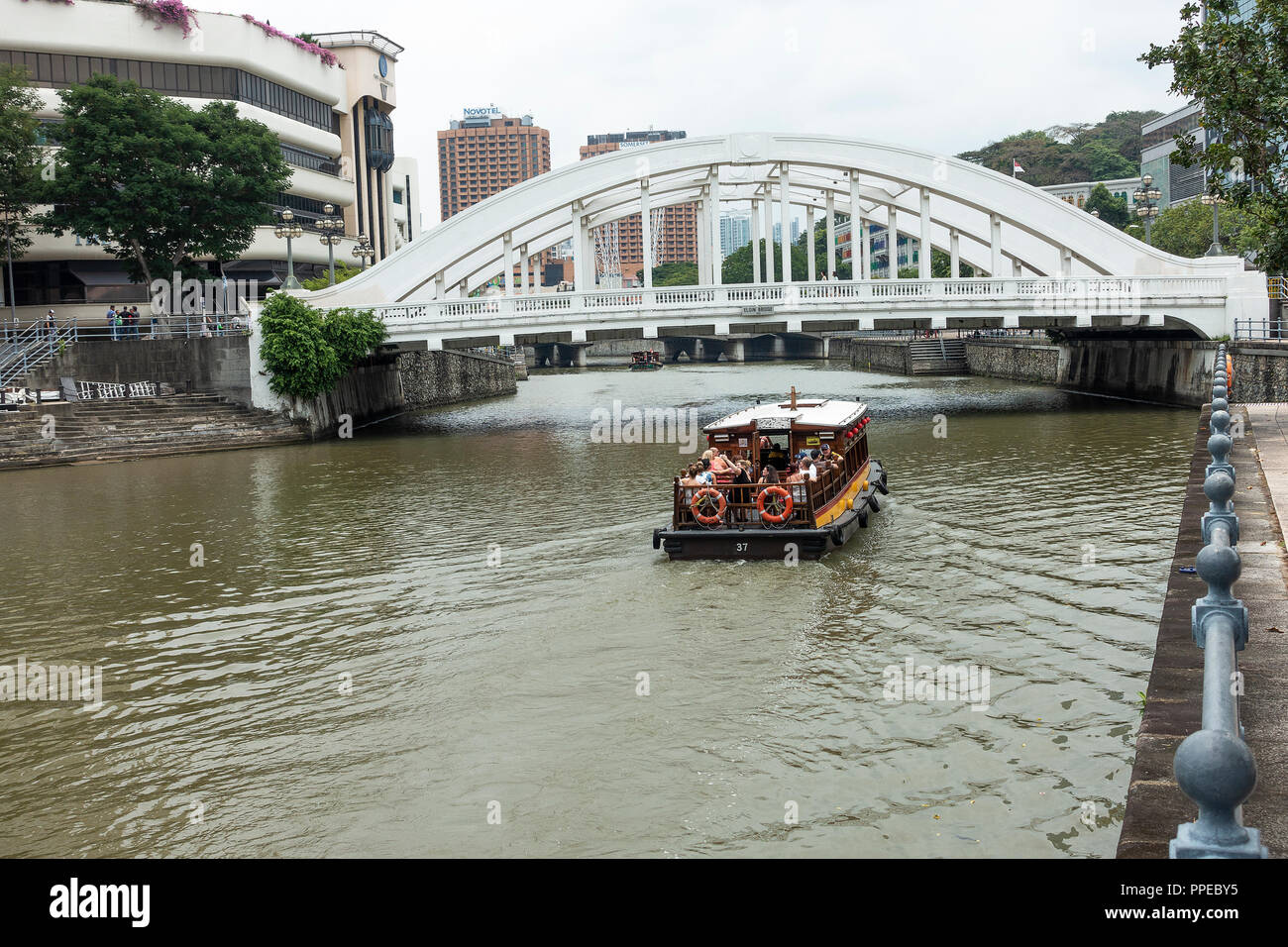 L'Elgin Bridge River Crossing avec bateau taxi touristique sur la rivière Singapour avec le Riverwalk immeuble en copropriété à Singapour Banque D'Images