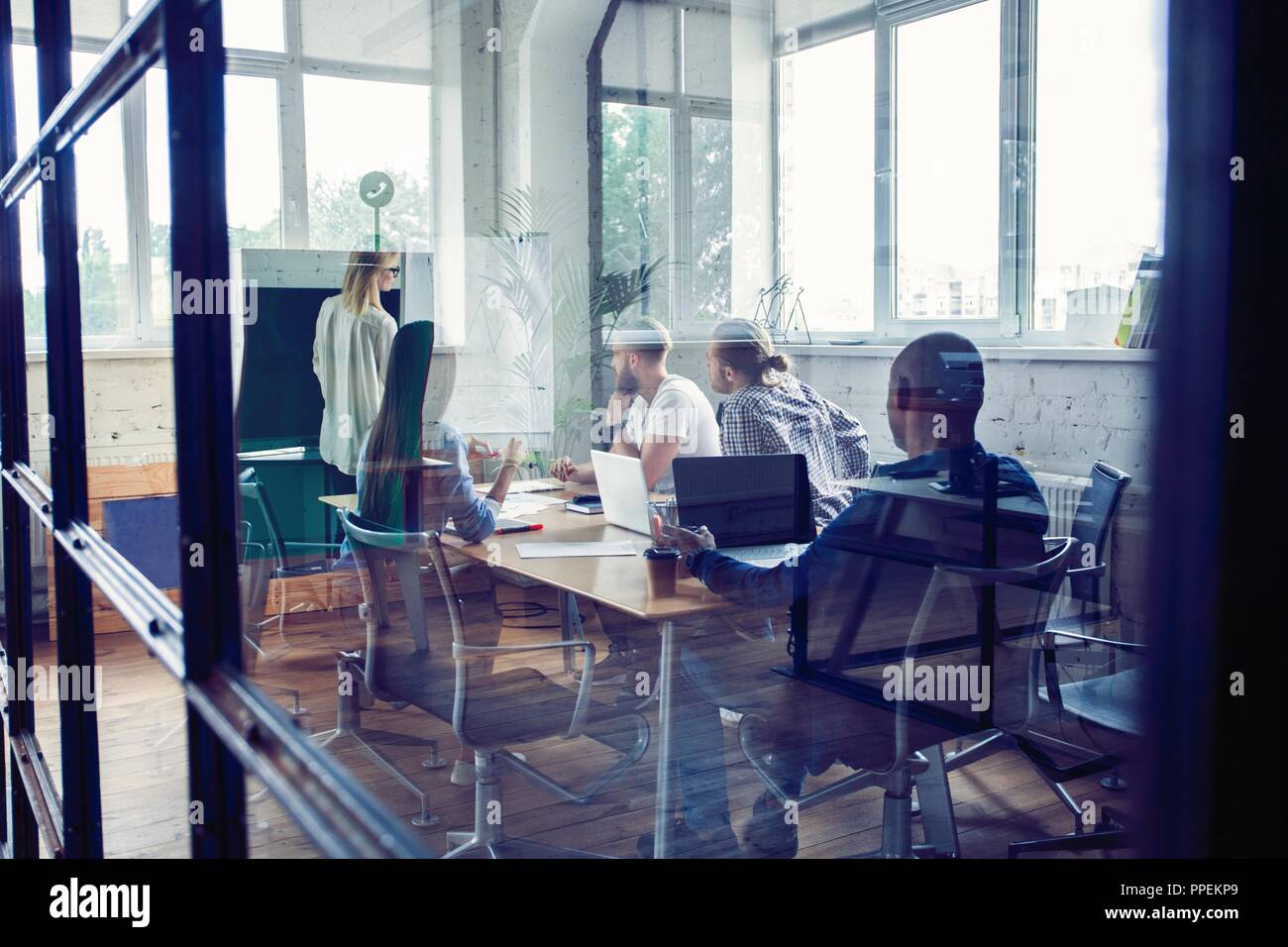Travailler dur pour gagner. Businesswoman effectuant une présentation d'affaires à l'aide d'un chevalet tout en travaillant dans le bureau de création. Banque D'Images
