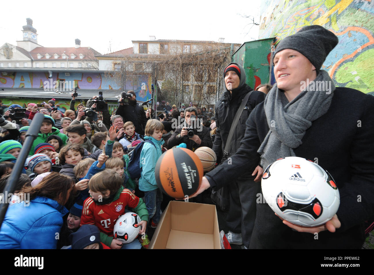 Bastian Schweinsteiger, joueur de football au FC Bayern Munich, distribue 100 boules pour les enfants lors d'une manifestation pour la sauvegarde de la terrain de sport au centre communautaire dans Glockenbachwerkstatt la Blumenstrasse. Dans l'arrière-plan, Peter Bruger de Sportfreunde Stiller. Banque D'Images