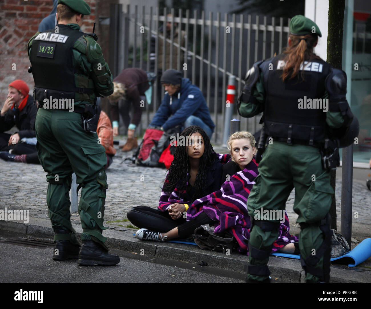 Deux spectateurs assister l'expulsion du camp par la police. Les réfugiés ont fait une grève de la faim il y a 8 jours au Rindermarkt à Munich pour démontrer pour de meilleures conditions de vie et de traitement. Banque D'Images