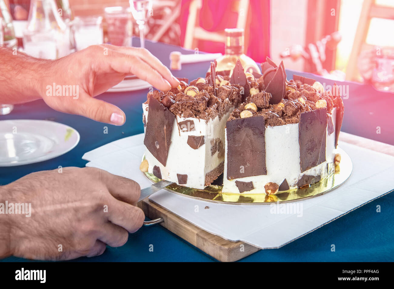 Un Grand Morceau De Gateau Au Chocolat Sur Une Plaque Les Mains Des Hommes Couper Le Gateau Photo Stock Alamy
