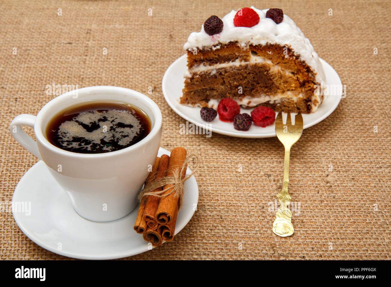 Tasse De Cafe De La Cannelle De La Fourche Et La Tranche De Biscuit Gateau Decore Avec De La Creme Fouettee Et De Framboises Sur La Table D Un Sac Photo Stock