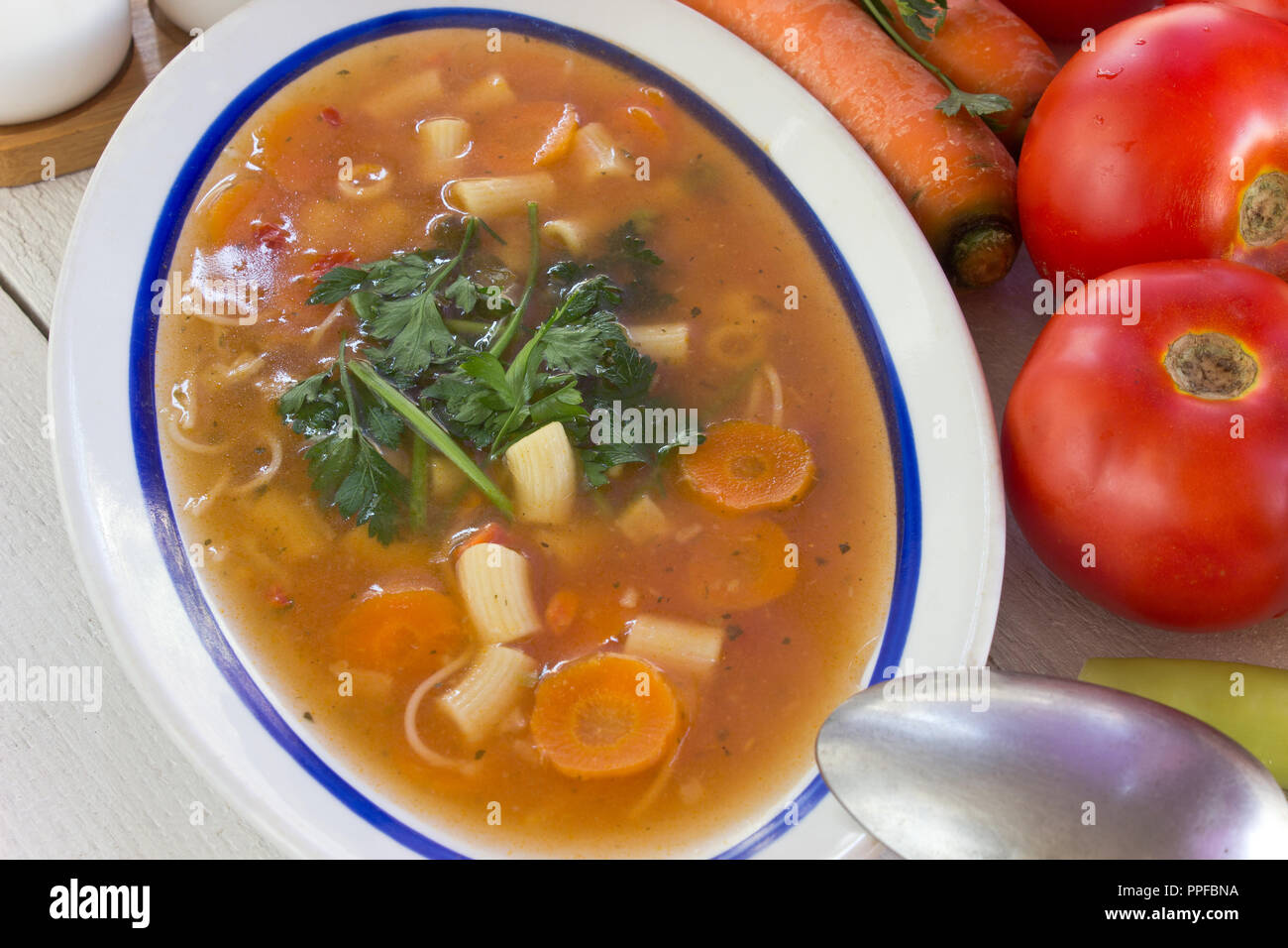 Minestrone de la plaque sur la table en bois blanc Banque D'Images