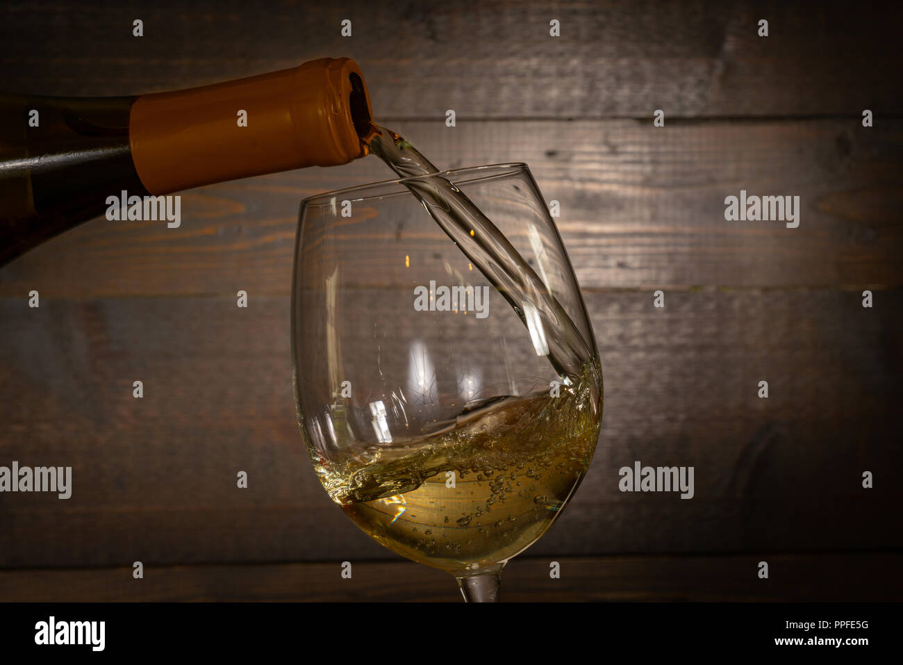 Le vin blanc et verser dans un verre à vin d'un bottel Banque D'Images