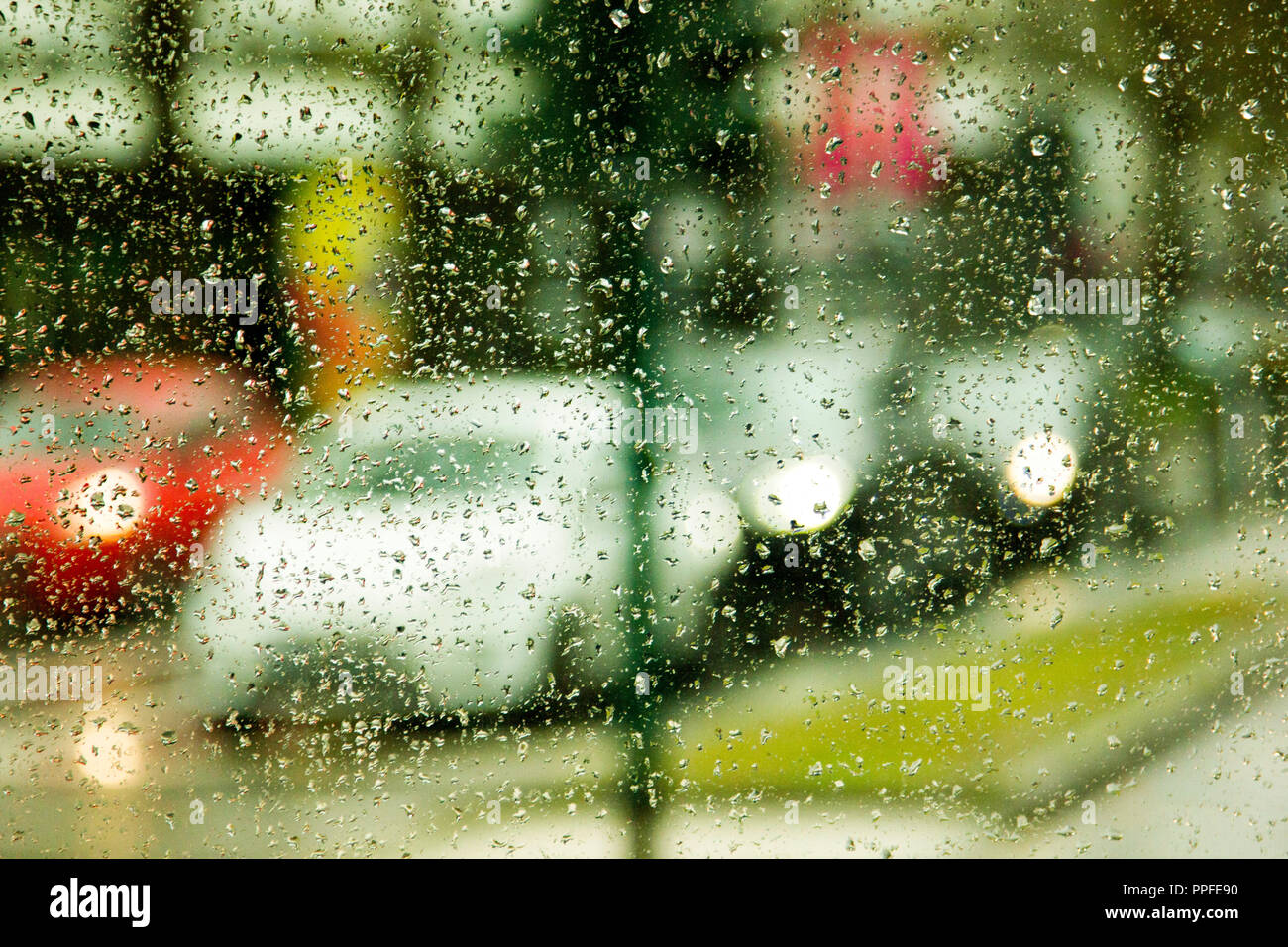 Jour de pluie sur la rue à travers les vitres de voitures avec des gouttes de pluie Banque D'Images