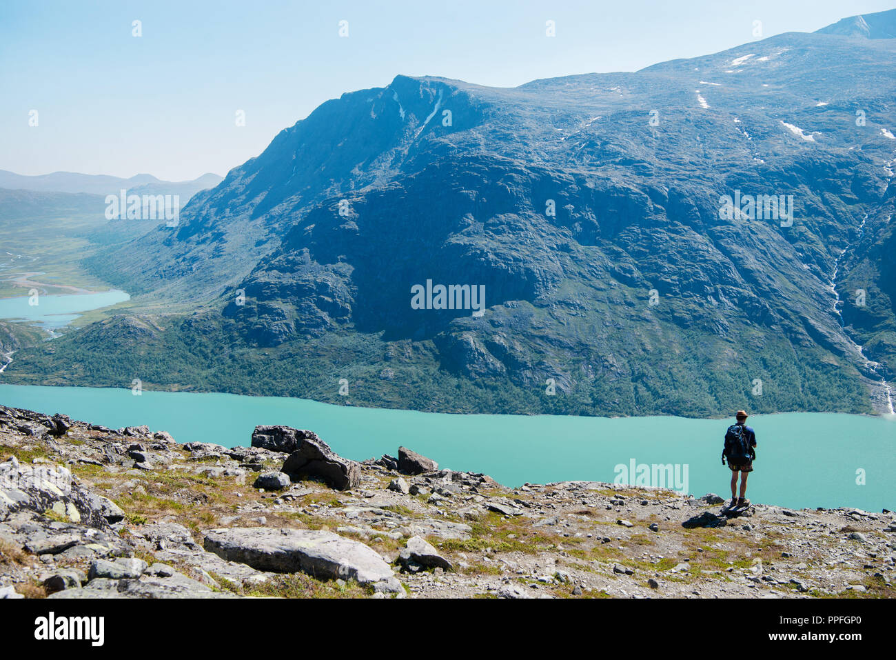 Randonneur sur Besseggen permanent ridge et regardant le lac Gjende dans le parc national de Jotunheimen, Norvège Banque D'Images