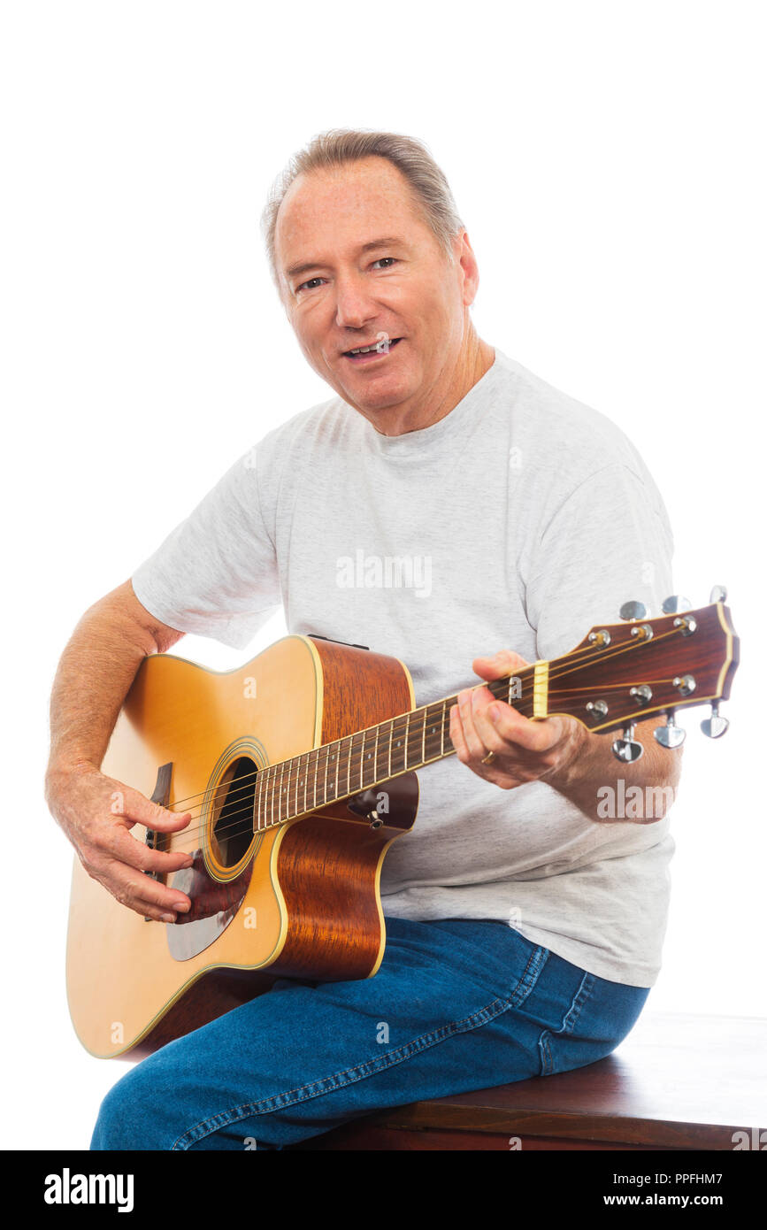 Gros plan vertical d'un homme mûr heureusement jouant de sa guitare sur un fond blanc. Copier l'espace. Banque D'Images