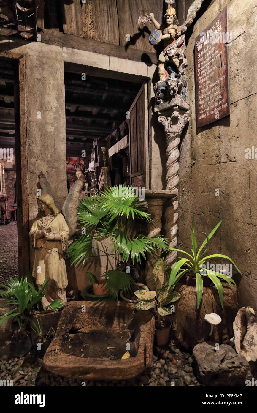 Jardin intérieur avec sculptures sur bois de Saint Michel Archange et de plantes en plantpots-Filipino maison ancestrale à l'Mabini et Lopez Jaena rue c Banque D'Images