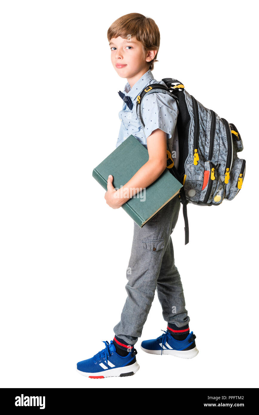 Jeune garçon avec sac à dos holding big book, isolé sur fond blanc Banque D'Images