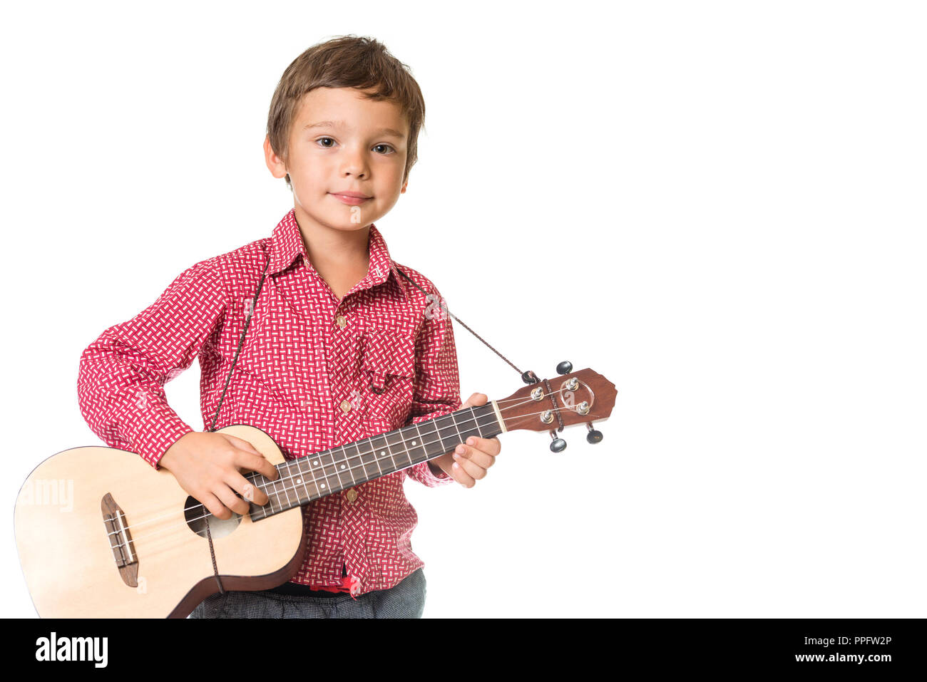 Adorable jeune garçon jouant le ukulélé, isolé sur fond blanc avec un espace réservé au texte Banque D'Images