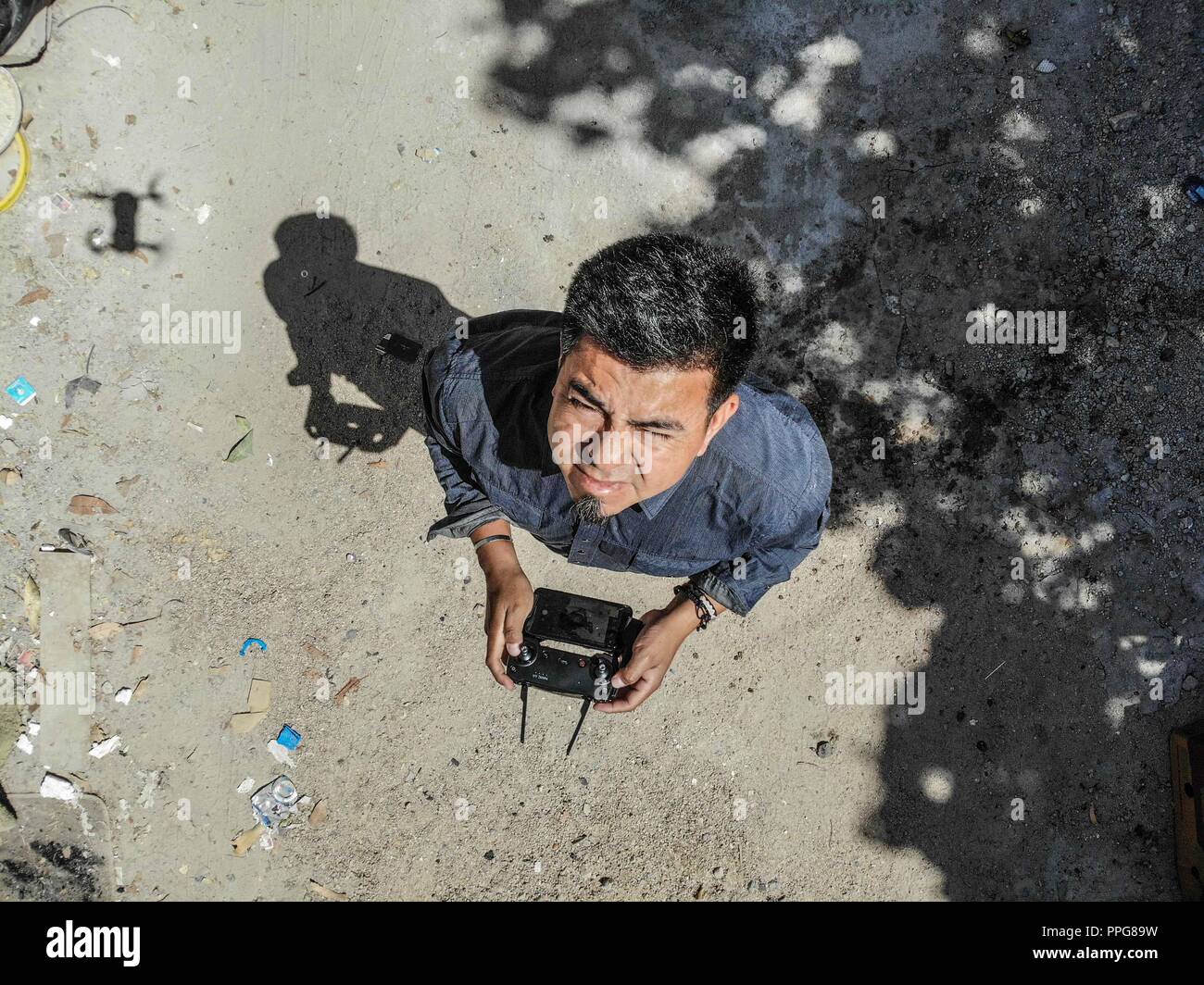 Auto-portrait de Luis Gutierrez, photographe, photojournaliste. battant un bourdon dans la cour de la maison de ses parents. Quartier populaire progressiste. Banque D'Images