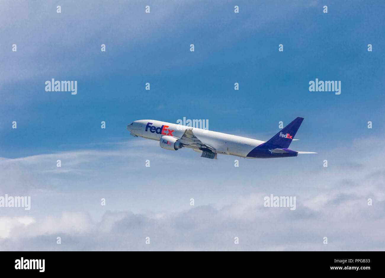 Fret de FedEx avion au décollage à Anchorage en Alaska dans un ciel bleu avec des nuages blancs Banque D'Images