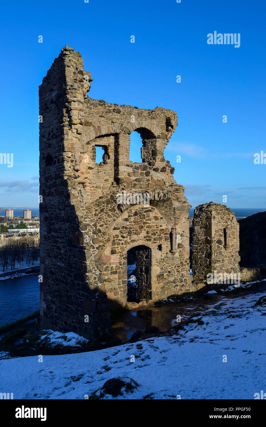 Ruines de la chapelle Saint Antoine dans la neige, avec St Margaret's Loch en arrière-plan, le parc de Holyrood, Édimbourg, Écosse Banque D'Images