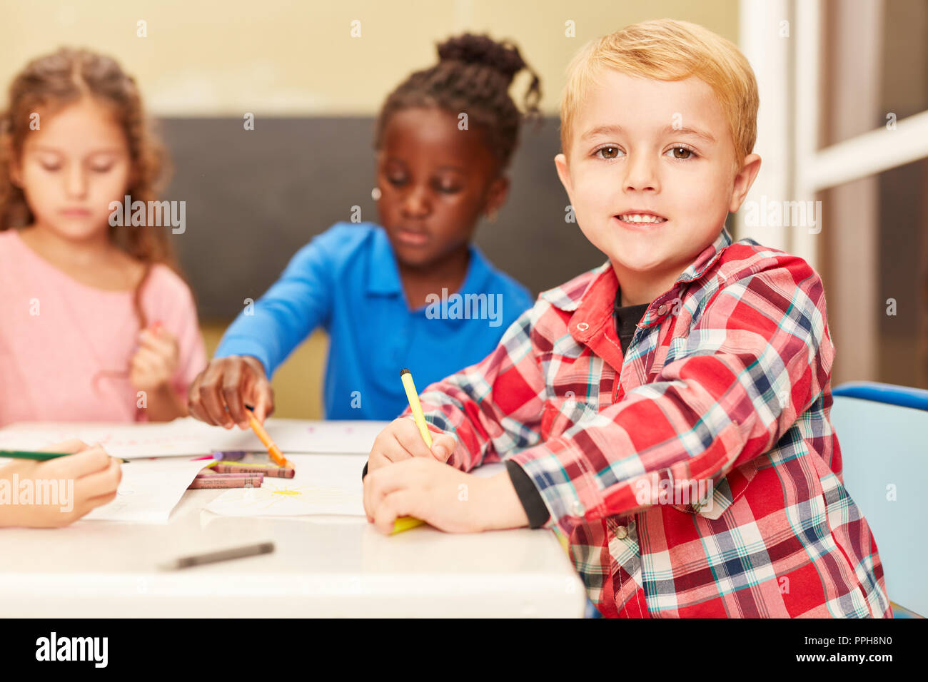 Garçon comme un élève ou un bambin tandis que la peinture en classe de peinture en maternelle ou à la garderie Banque D'Images