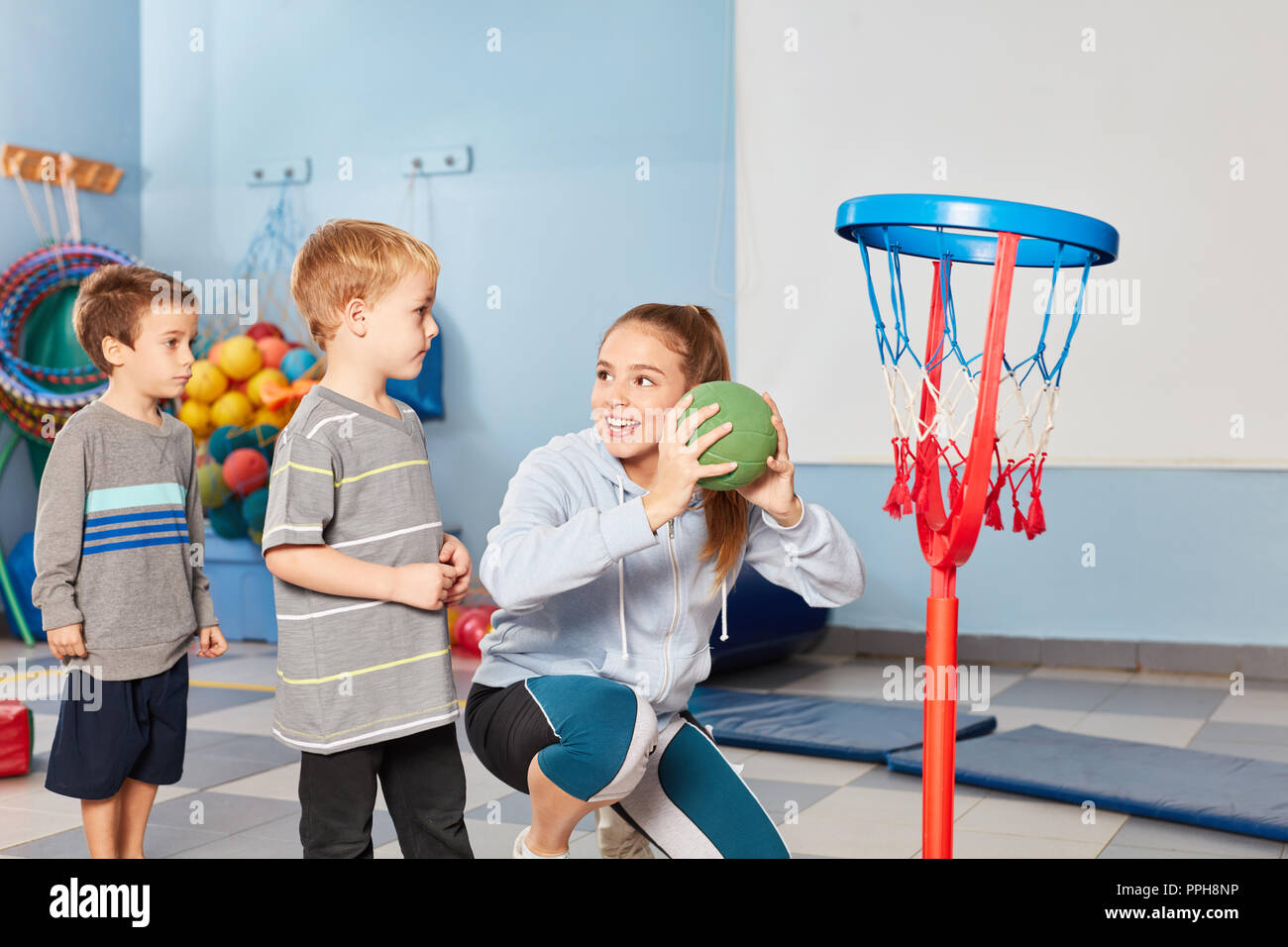 Professeur de sport et les enfants jouer au basket-ball ensemble dans la  salle de sport d'enfants d'âge préscolaire Photo Stock - Alamy