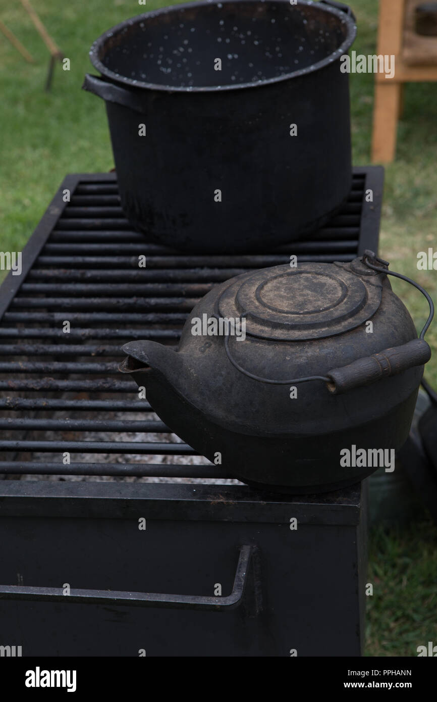 Ancienne en fonte noire électrique sur une grille d'un barbecue en plein air au bois Banque D'Images
