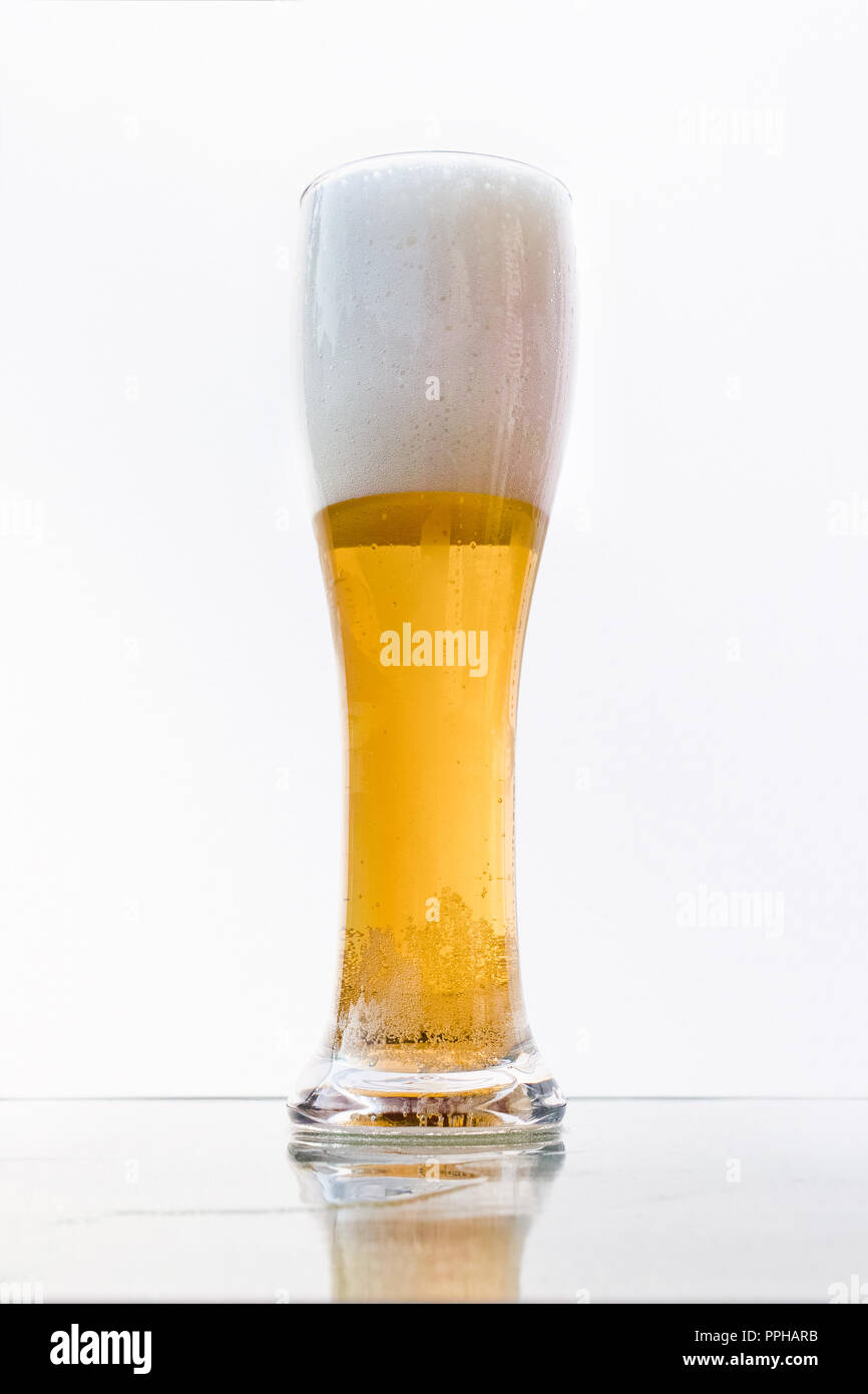 Une pinte de bière blonde sur une surface transparente. Banque D'Images