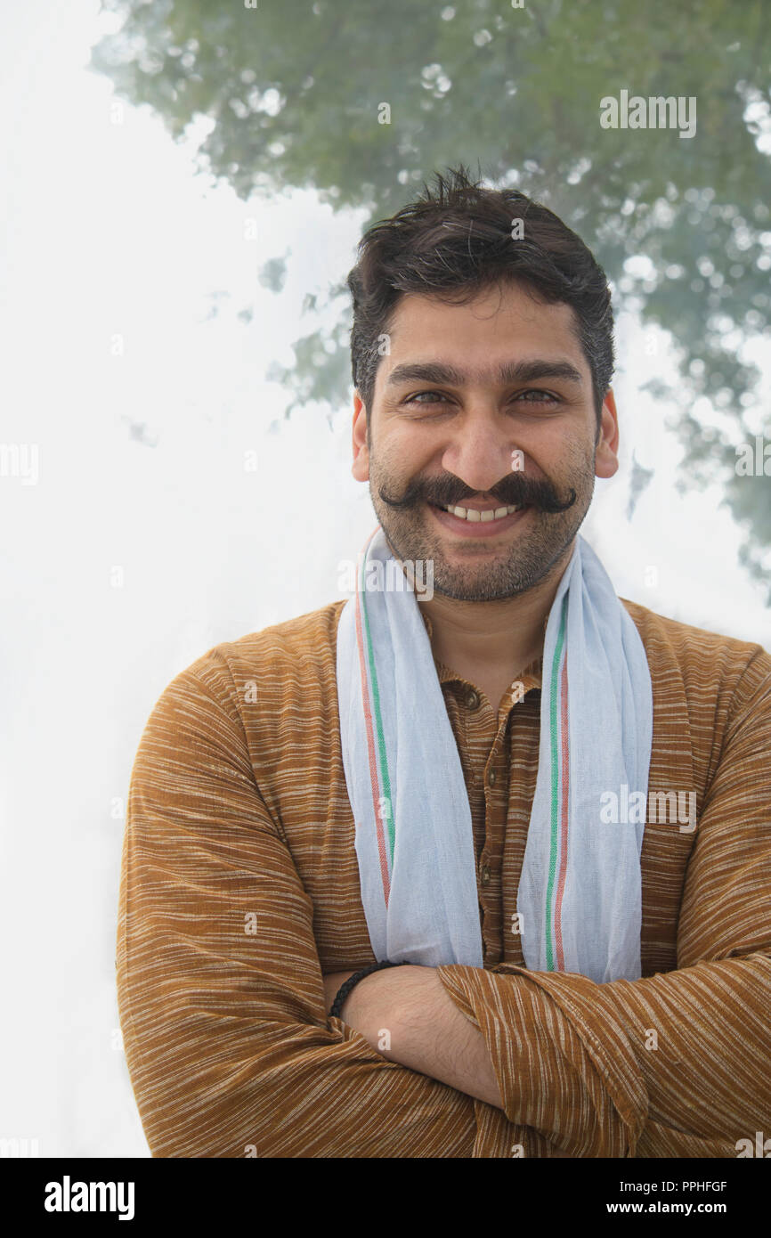Portrait of a smiling man village ayant enroulé moustache debout, les bras croisés. Banque D'Images Portrait of a smiling man village ayant enroulé moustache debout, les bras croisés. Banque D'Images