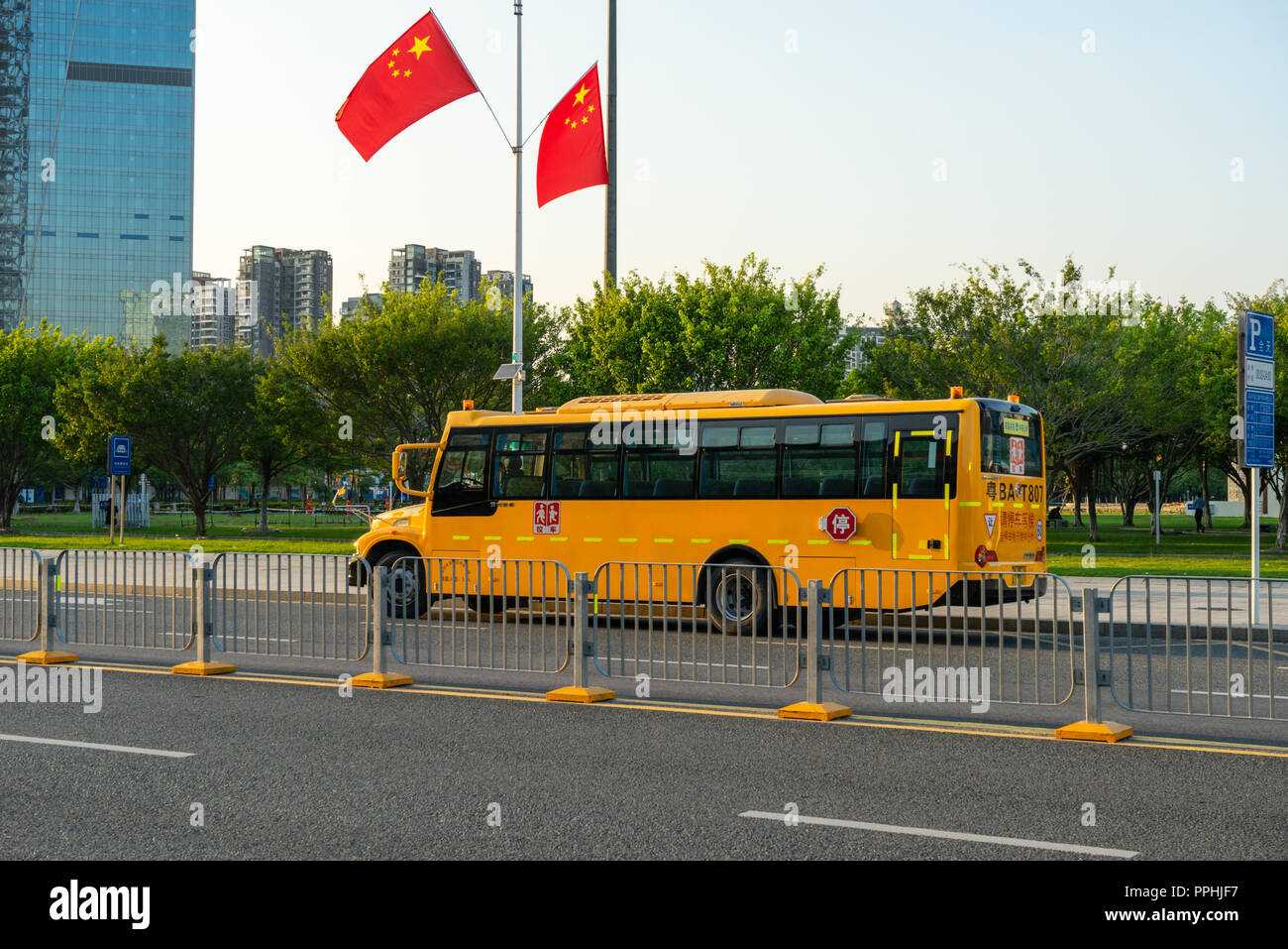Autobus scolaire chinois avec des drapeaux chinois en arrière-plan Banque D'Images