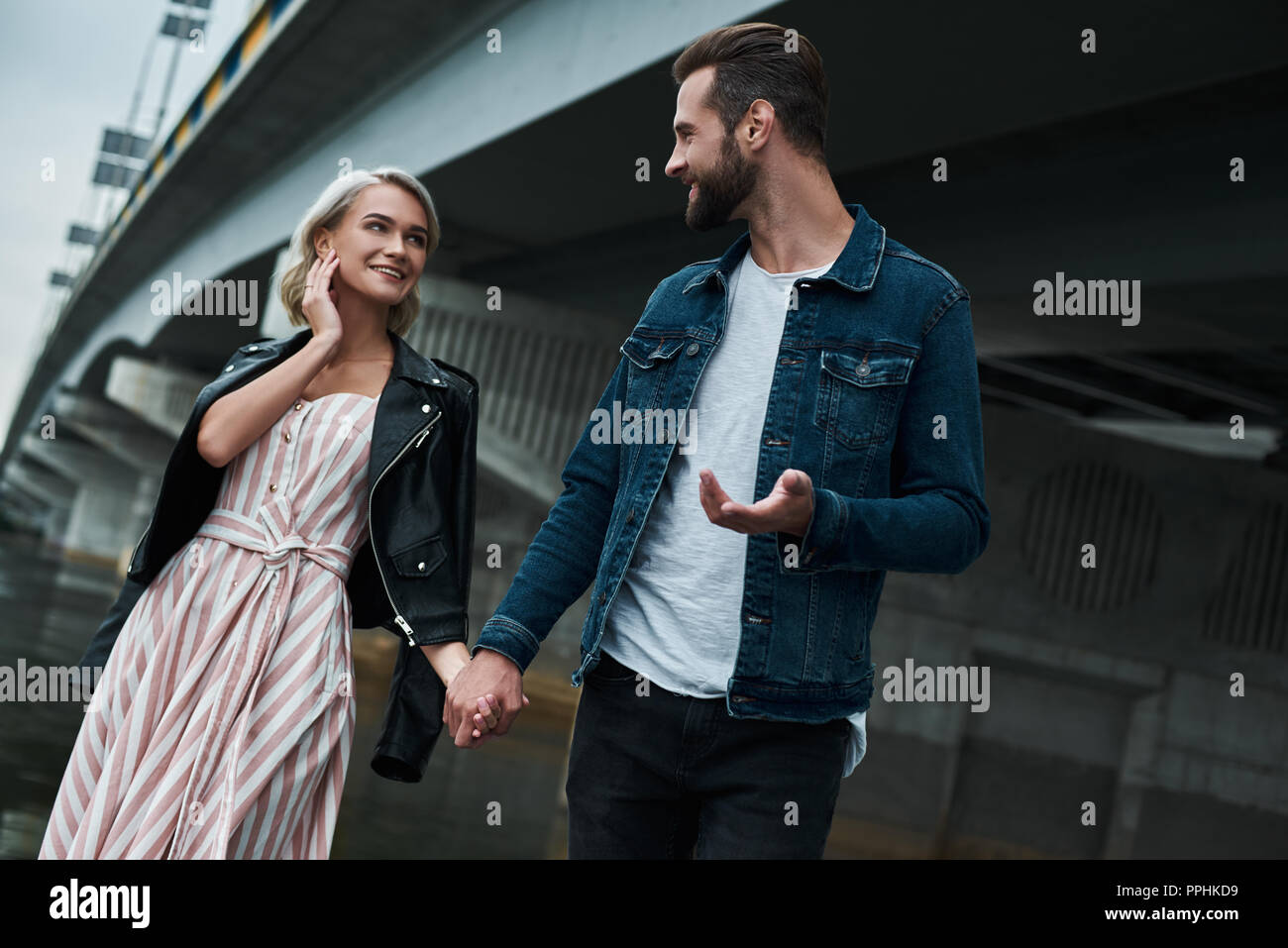 Date romantique en plein air. Jeune couple en train de marcher sur la ville main dans la rue parler joyeux sourire Banque D'Images