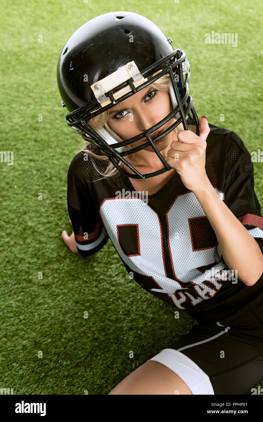 Jeune femme en colère en uniforme de football américain sitting on grass  Photo Stock - Alamy