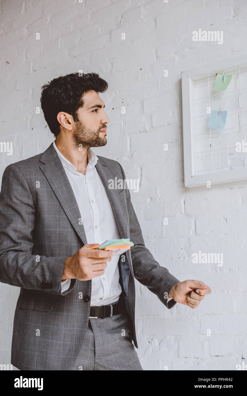 Handsome businessman holding paper autocollants et à la tâche à l'office de conseil Banque D'Images