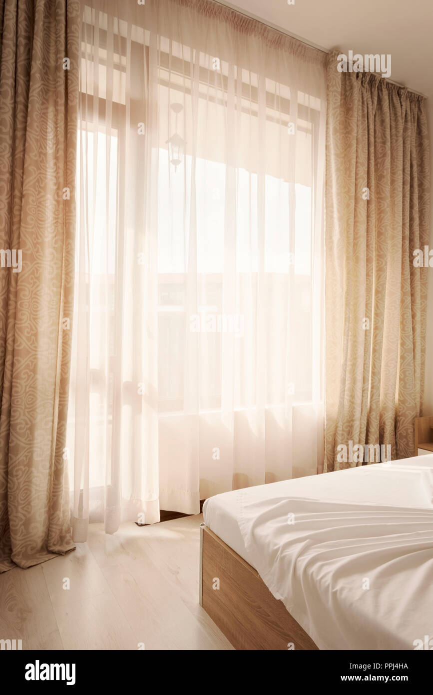 Intérieur de l'hôtel. Long des rideaux beiges et des rideaux, voilages de  tulle sur une fenêtre dans la chambre. Concept de design d'intérieur Photo  Stock - Alamy