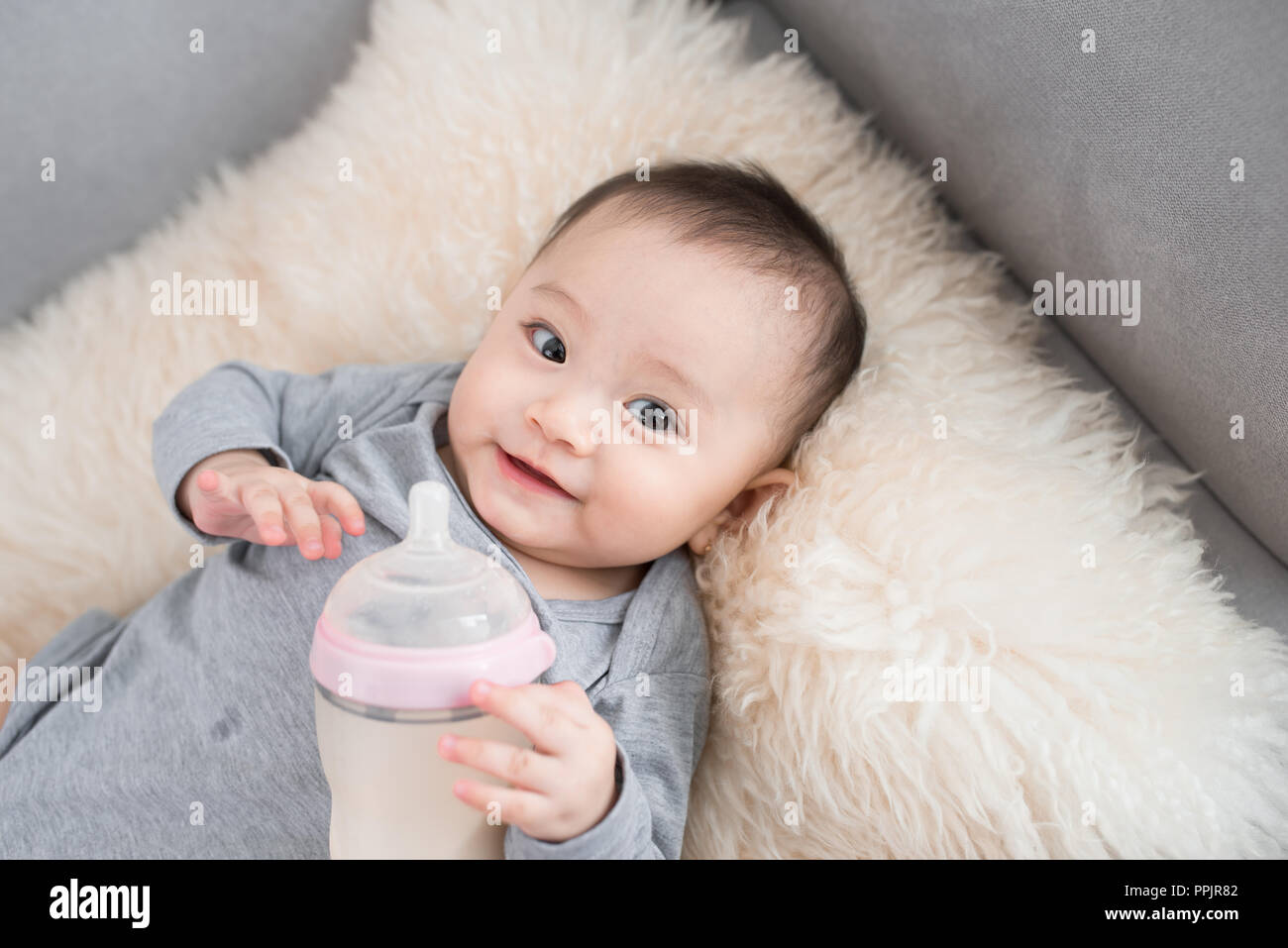 L'alimentation du nourrisson bébé asiatique de lait bouteille, 9 mois après la naissance Banque D'Images