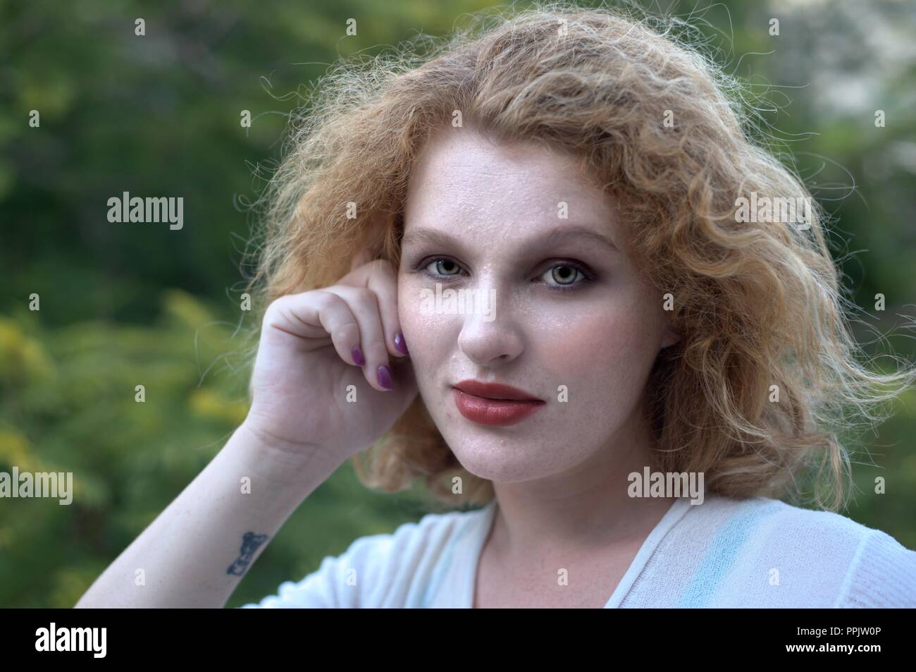 Portrait de jeune femme blonde, fond vert Banque D'Images