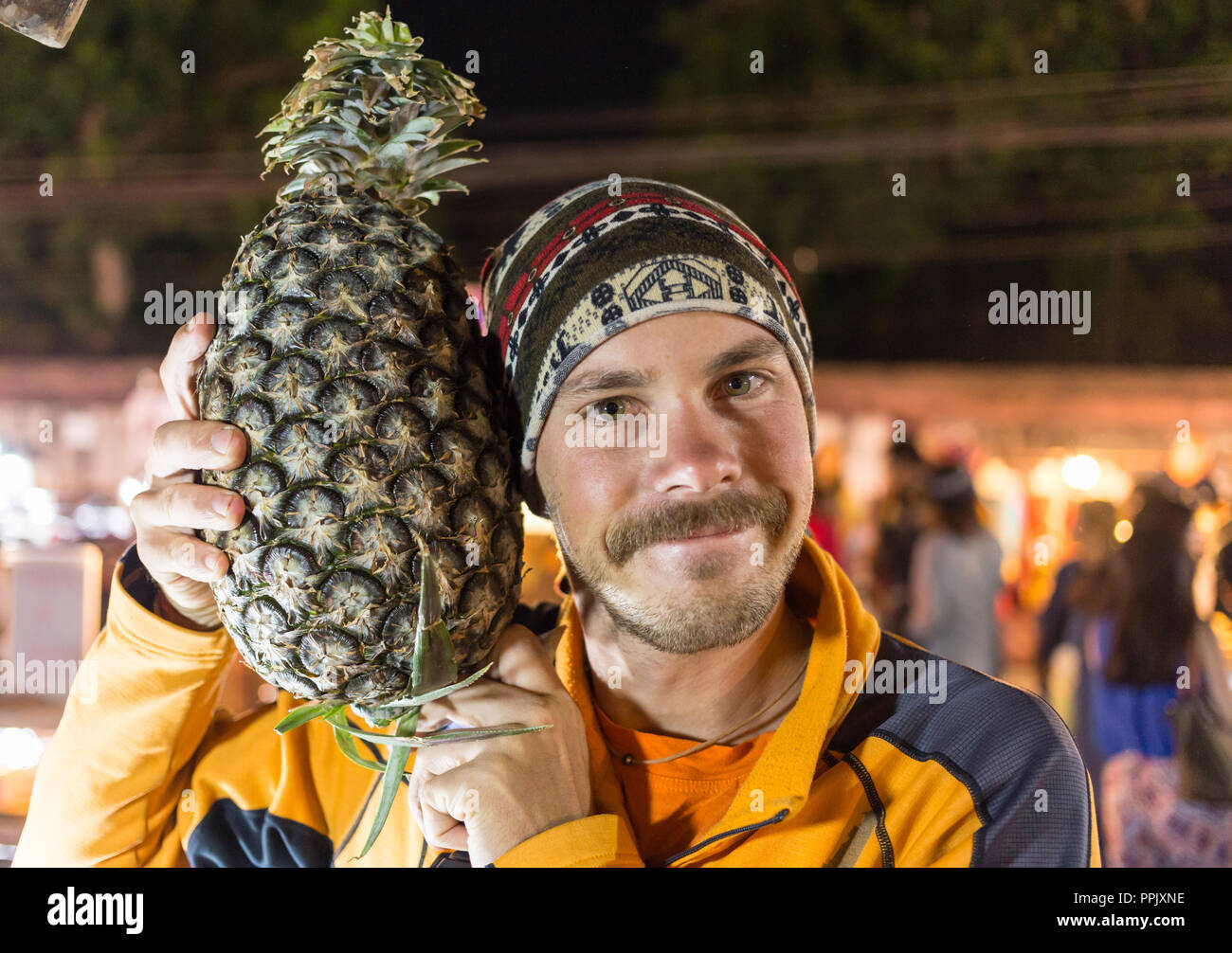 Portrait de l'homme drôle avec beaucoup d'ananas. Banque D'Images