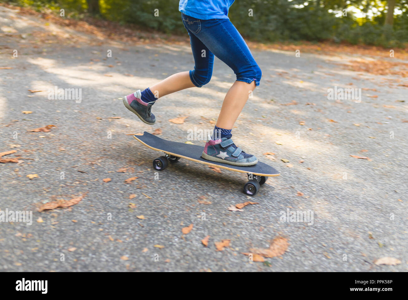 Un enfant est de patiner sur un longboard, close-up Banque D'Images