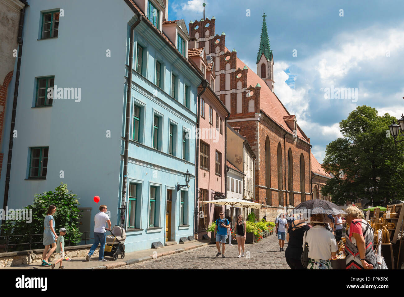 La vieille ville de Riga, voir des gens marcher dans et en regardant les étals de marché près de St John's Church in Skarnu Iela dans le centre médiéval de la vieille ville de Riga, Lettonie. Banque D'Images