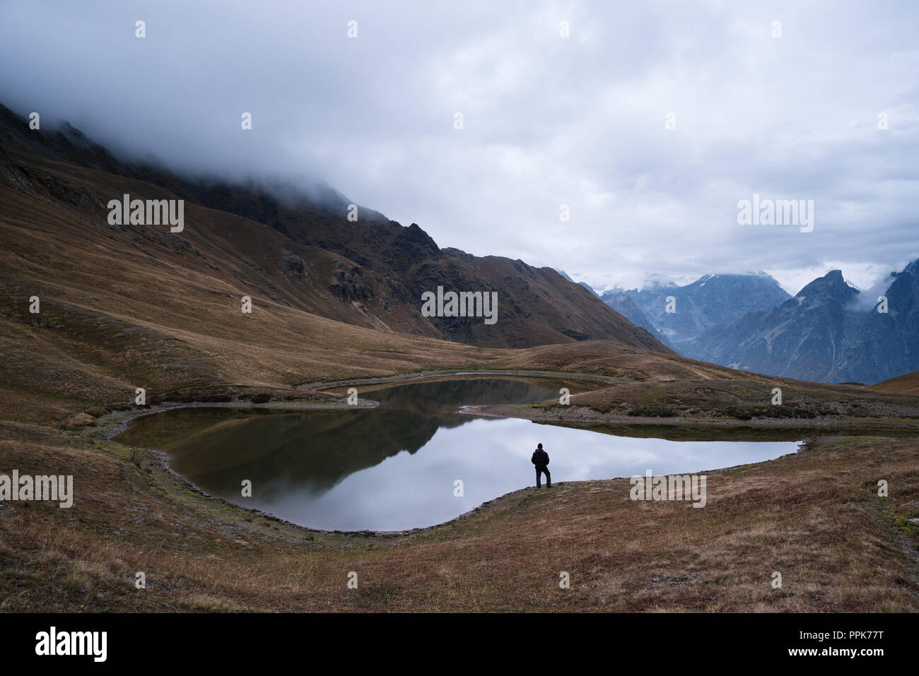 Lac de montagne Koruldi. Vue de la crête du Caucase Principale. Touriste jouit d'un emplacement pittoresque. Samegrelo-zemo svaneti, Géorgie Banque D'Images