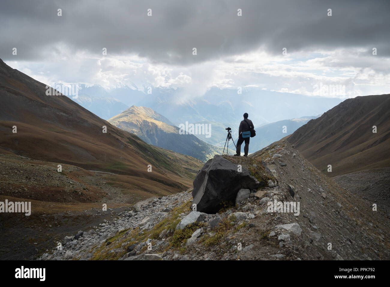 Photographe de paysage avec caméra et trépied dans les montagnes. Vue de la gamme Svan. La crête caucasienne Principale. Samegrelo-zemo Svaneti, Géorgie Banque D'Images