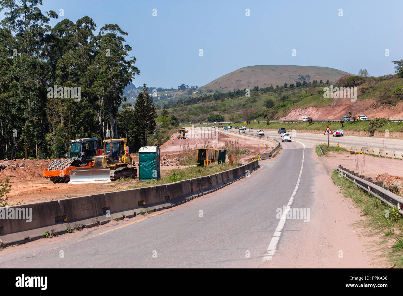 Nouvelle route des machines industrielles d'extension de l'autoroute à la construction terrassement route existante entre l'article. Banque D'Images