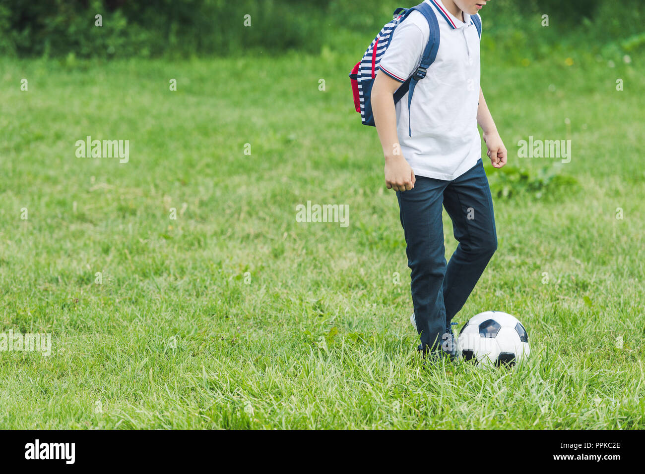 Cropped shot de kid jouer avec ballon de soccer sur grass field Banque D'Images