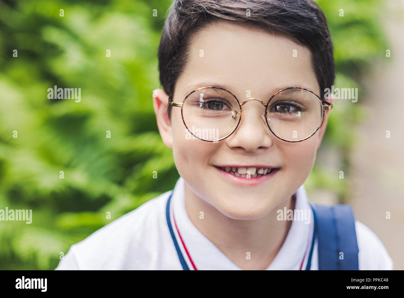 Close-up portrait of happy kid en lunettes rondes looking at camera Banque D'Images