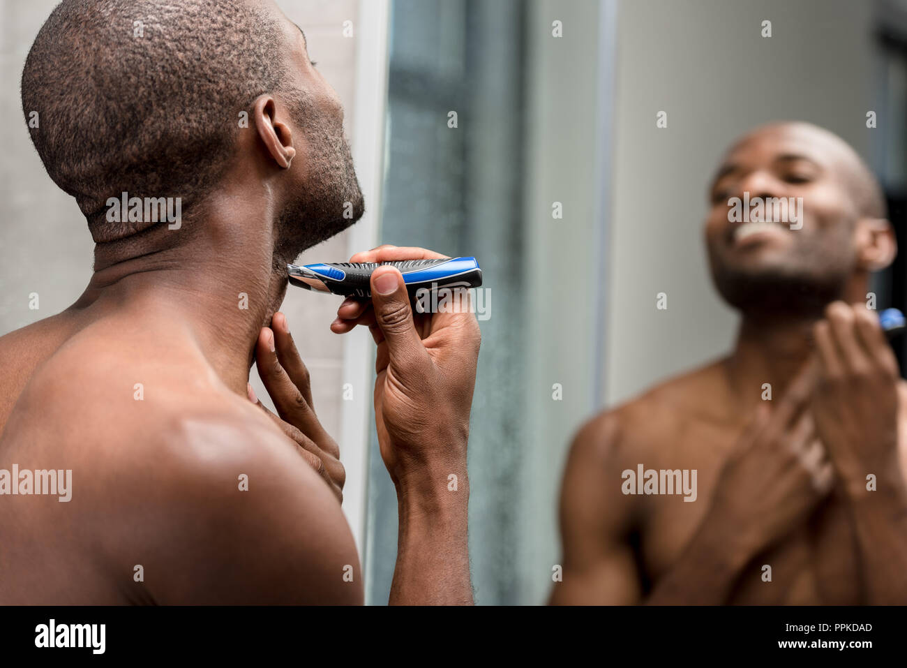 Les jeunes torse nu african american man avec rasage tondeuse électrique  dans la salle de bains Photo Stock - Alamy
