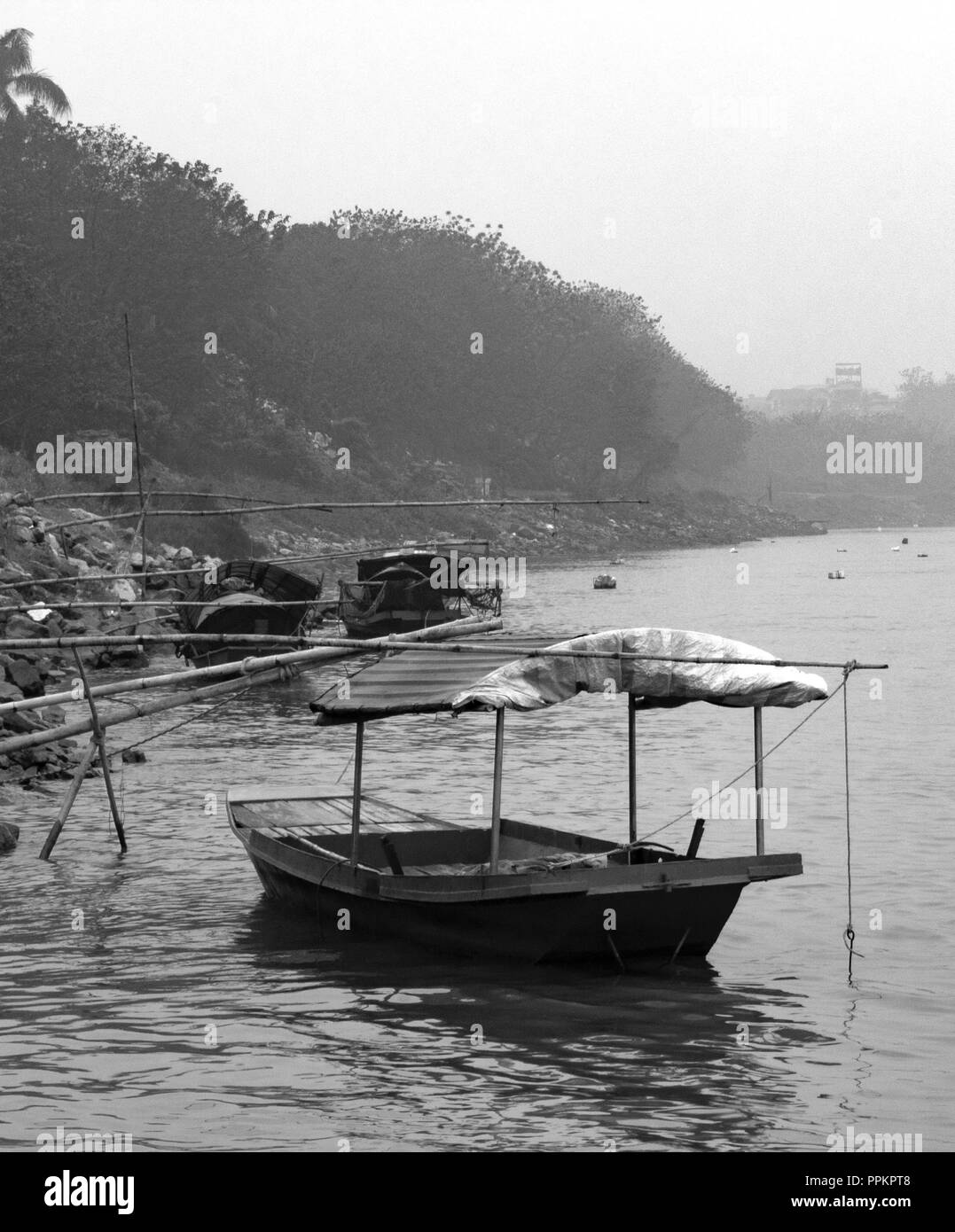 Petit bateau sur la rive de la rivière Rouge en noir et blanc Banque D'Images