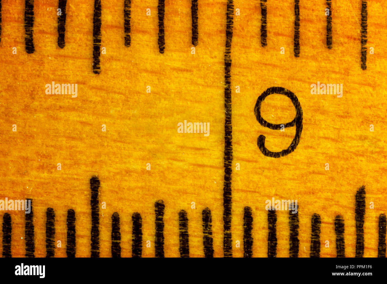 Numéro 9 sur une règle en bois , les lignes noires sur une règle jaune , vue de dessus ,composition horizontale ,macro photographie Banque D'Images