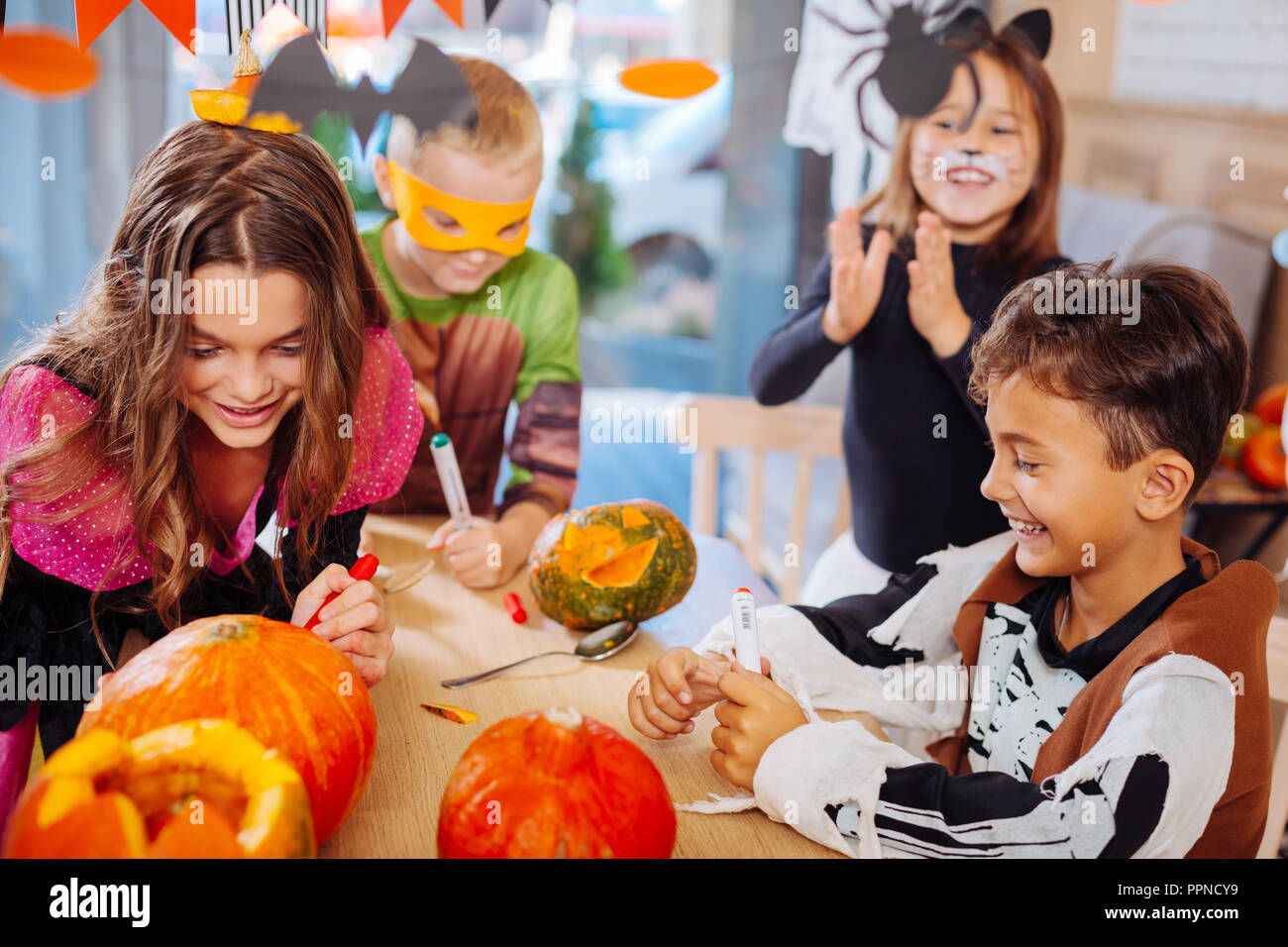 Quatre enfants qui fréquentent l'Halloween citrouilles coloriage ensemble Banque D'Images
