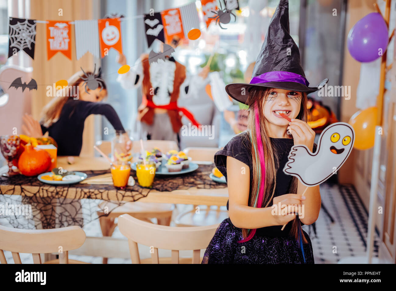 Assistant Girl wearing hat sentiment heureux participant à Scary Halloween Party Banque D'Images