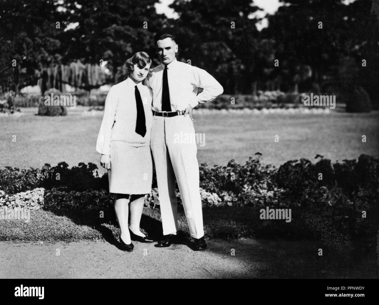 Des couples, homme et femme dans partenaire de regarder, ils en chemise blanche et jupe, il en chemise blanche et pantalon, les deux portant une cravate noire Banque D'Images