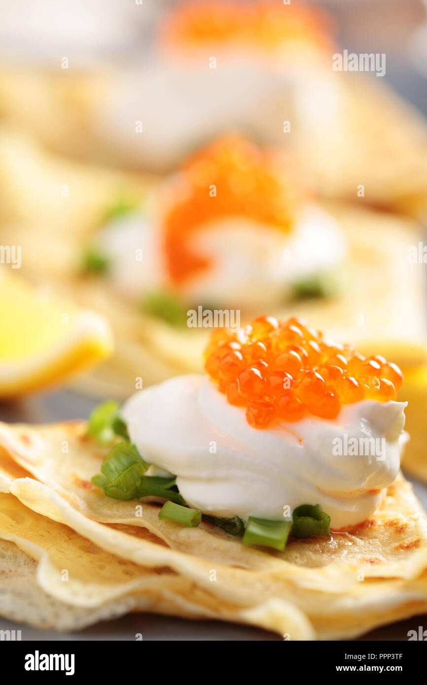 Crêpes avec du caviar rouge sur une plaque Banque D'Images