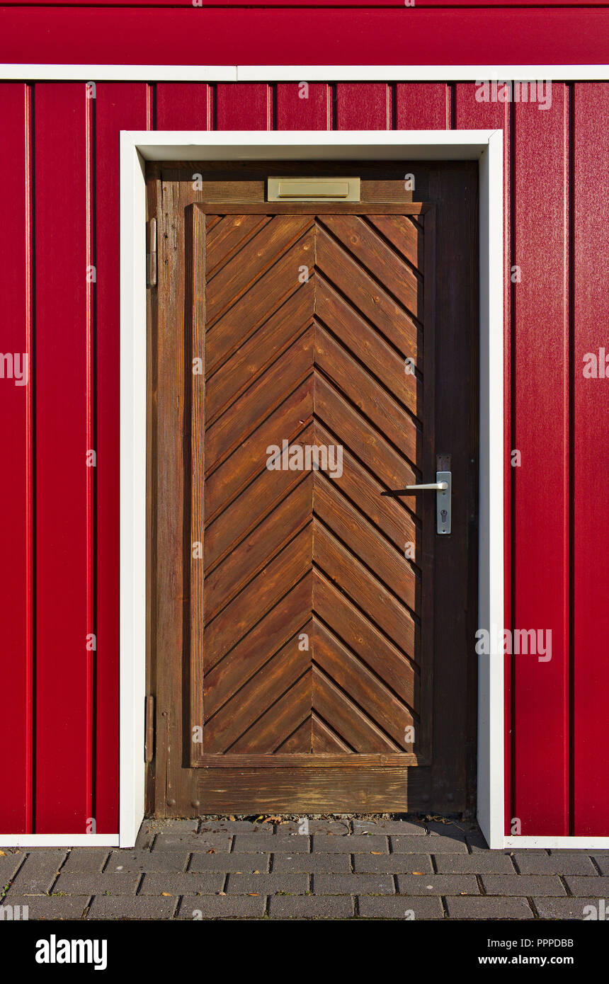 De style scandinave et de couleur rouge et blanc avec façade en bois brun porte à chevrons Banque D'Images