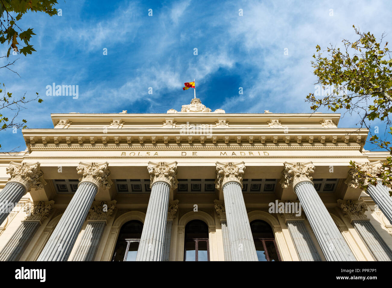 À angle faible affichage des colonnes et façade néoclassique de la Bolsa de Madrid (Madrid Stock Exchange) contre un ciel bleu nuageux. Banque D'Images