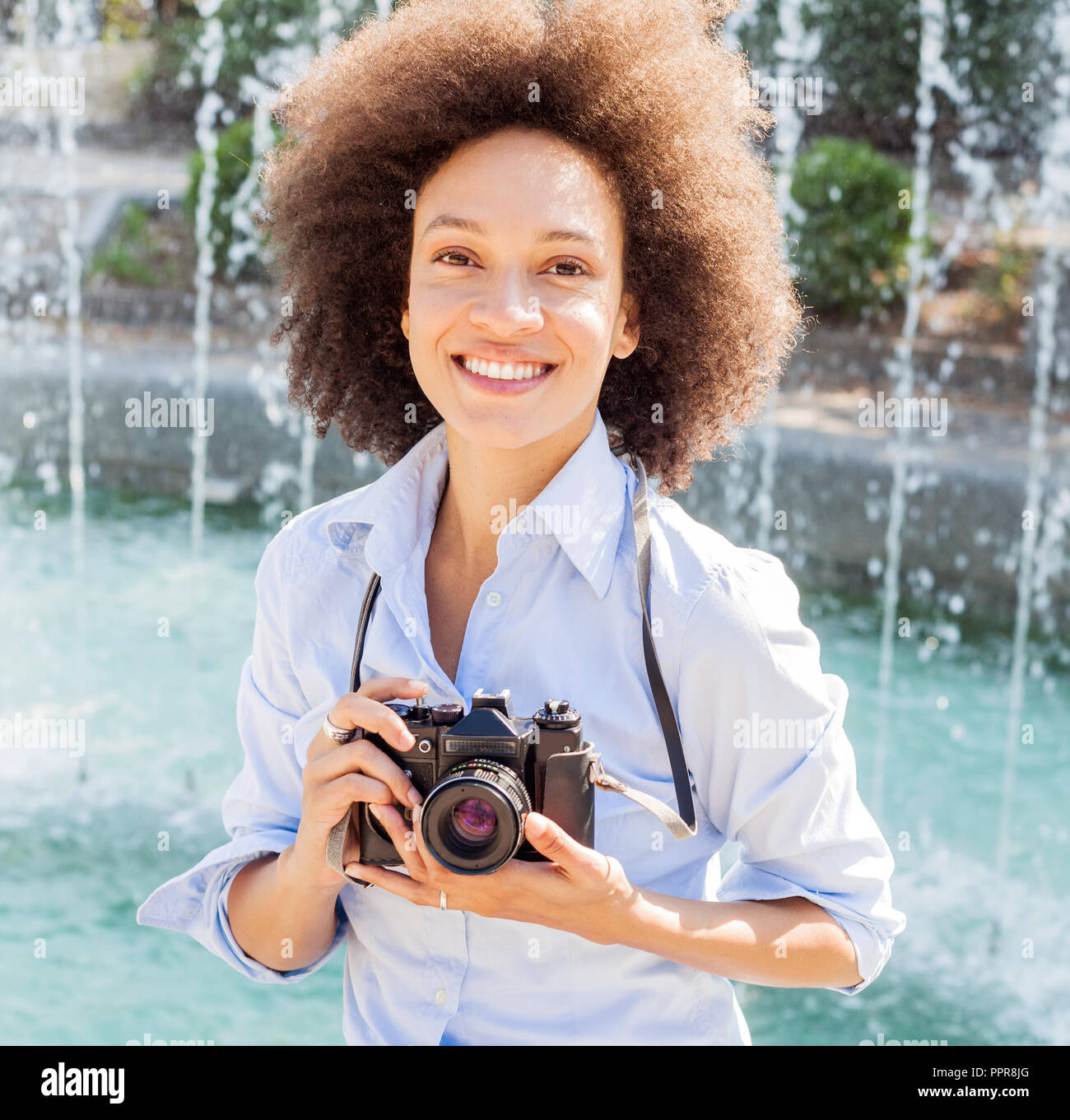 Portrait de femme noire charme rétro avec appareil photo, femme photographe  outdoor,coiffure afro, porte des vêtements décontractés, looking at camera  Photo Stock - Alamy