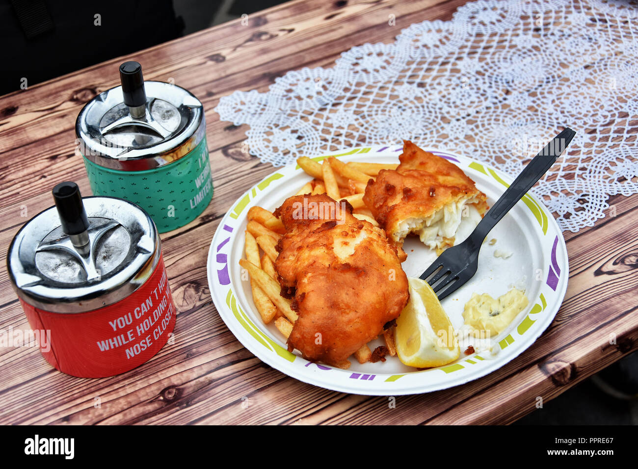 Table d'extérieur avec la plaque avec le poisson et frites à Brokiosken Jafs Restaurant connu pour les meilleurs aliments au centre, près de Harbour, à Alesund, Norvège. Banque D'Images